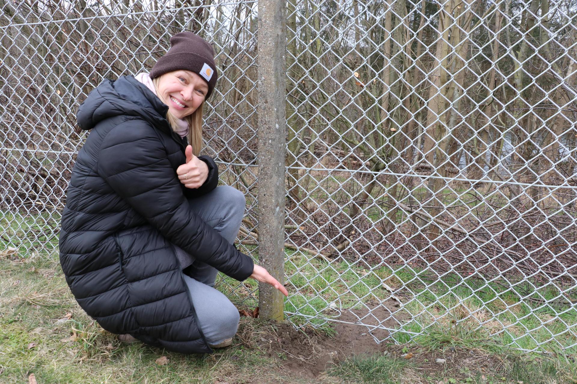 Melanie Dittmann zeigt auf das Loch im Zaun, durch das die Kugel entwischte.  (Foto: gi)