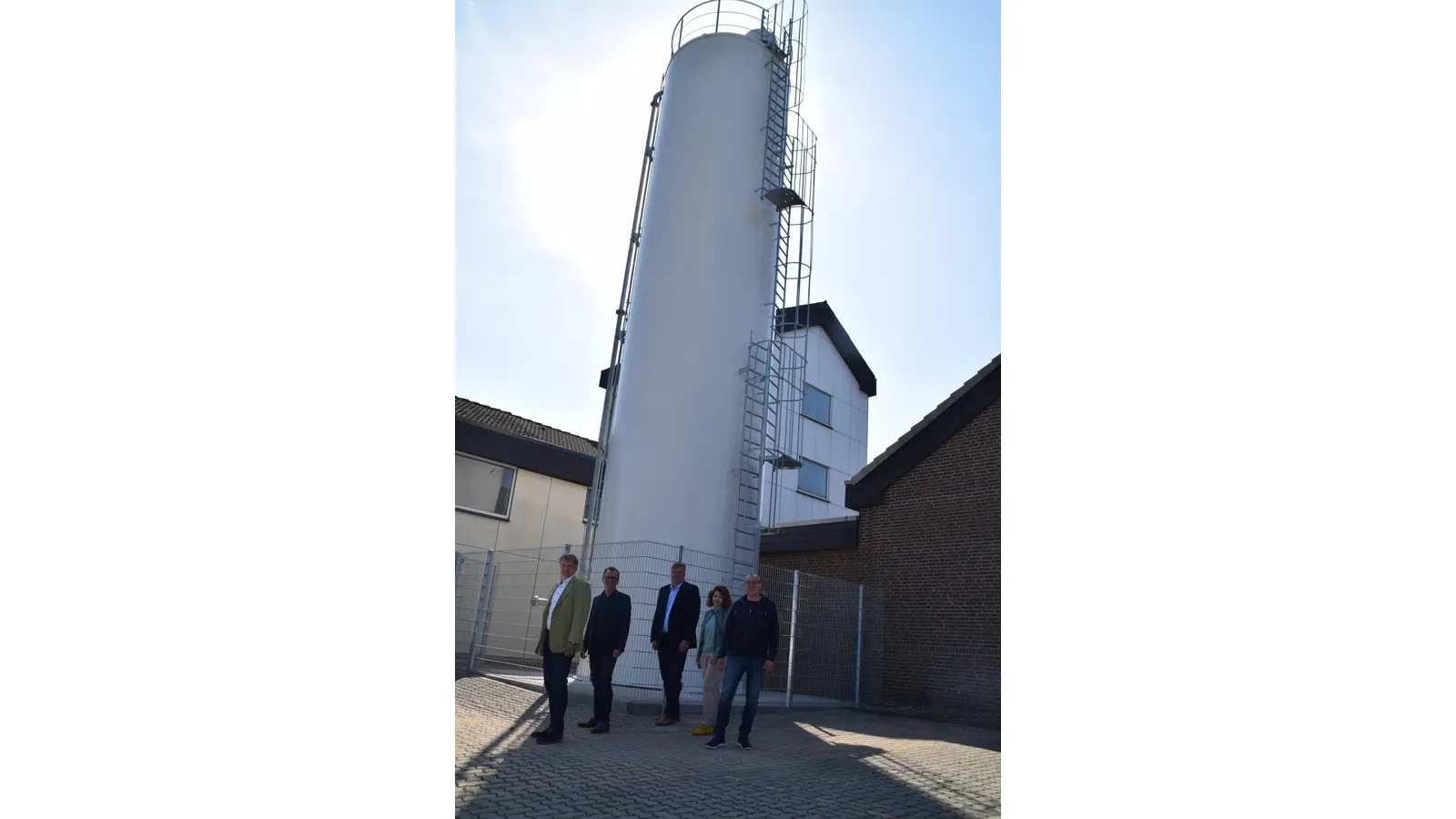 (v.l.n.r.) Bürgermeister Oliver Theiß, Dirk Rabeneck, Michael Sukoll, Anja Steffen-Ohme (Stadtwerke Schaumburg-Lippe), Rudi Kuppe (Wasserwerk Wendthagen-Ehlen) vor dem Silo -15 Meter hoch, 3,2 Meter Durchmesser.  (Foto: ab)