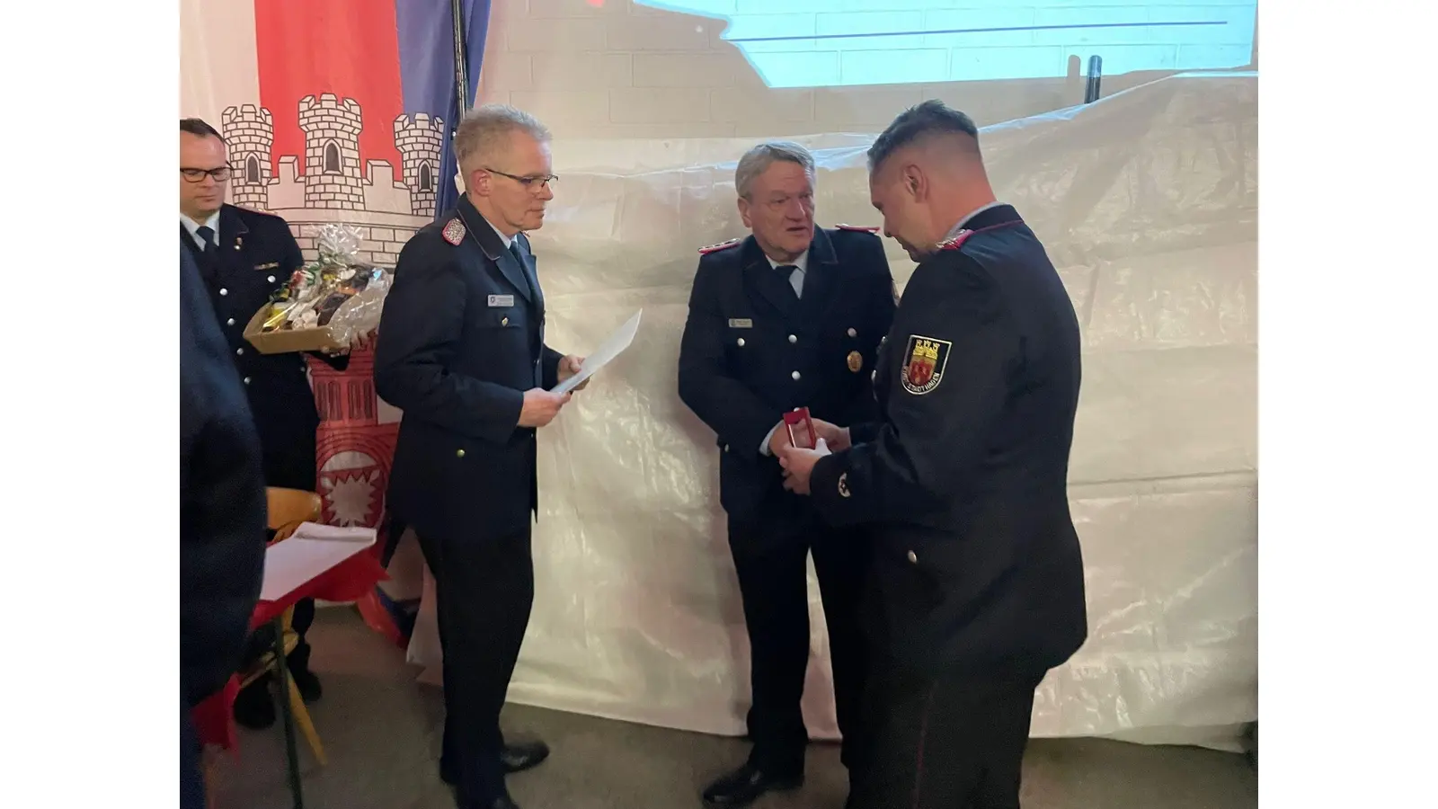 Kreisbrandmeister Klaus Peter Grote (li.) und Stadtbrandmeister Martin Buhr (re.) ehren Klaus-Dieter Gerland. (Foto: Feuerwehr)