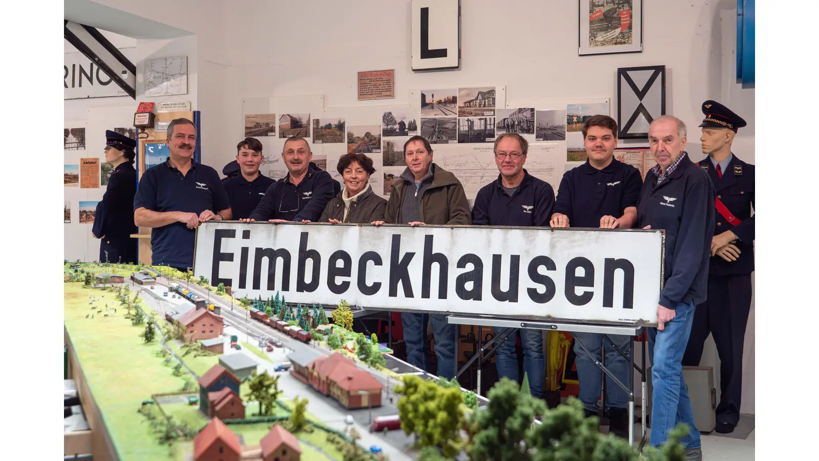 Bettina und Walfred Knopf (Mitte) beschenken die Eisenbahnfreunde Sünteltalbahn mit einem Bahnhofsschild aus Eimbeckhausen (Foto: wk)