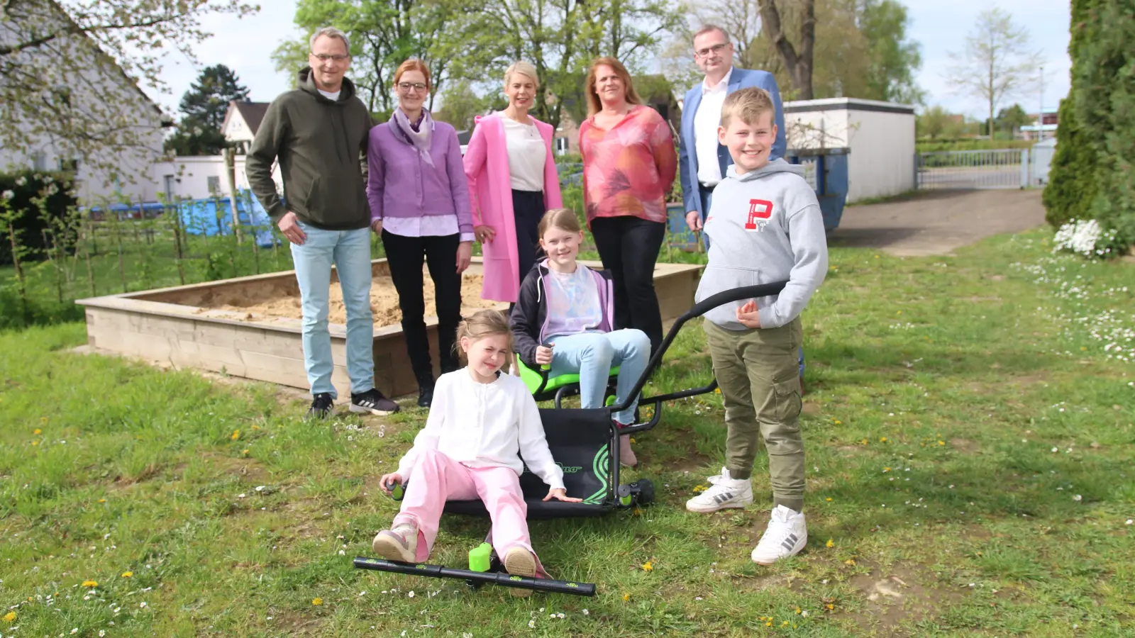 Luna, Lara und Linus probieren die neuen Spielgeräte schon einmal beim Übergabetermin mit Sven Unruh (hintere Reihe v. li. und Stefanie Sonnekalb-Unruh vom Förderverein der Grundschule, Miriam Schütte von der Lindhorster Geschäftsstelle der Volksbank in Schaumburg und Nienburg, Direktorin Christina Kutulla sowie Torsten Schmidt, Regionalleiter der Volksbank in Nienburg und Schaumburg, aus. (Foto: bb)