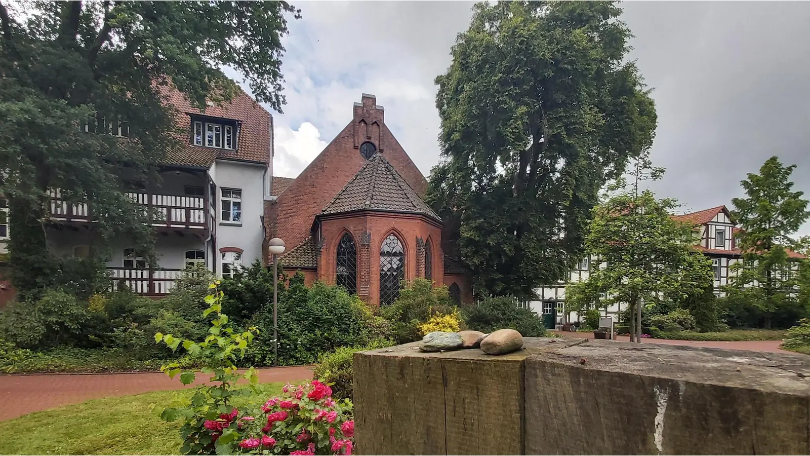 Beim Blick über die abgelegten Steine an einer Gedenkstele im Klinikpark, fällt der Blick auf die Klinikkapelle, dem Sammlungsort vor den Deportationen. (Foto: gk)