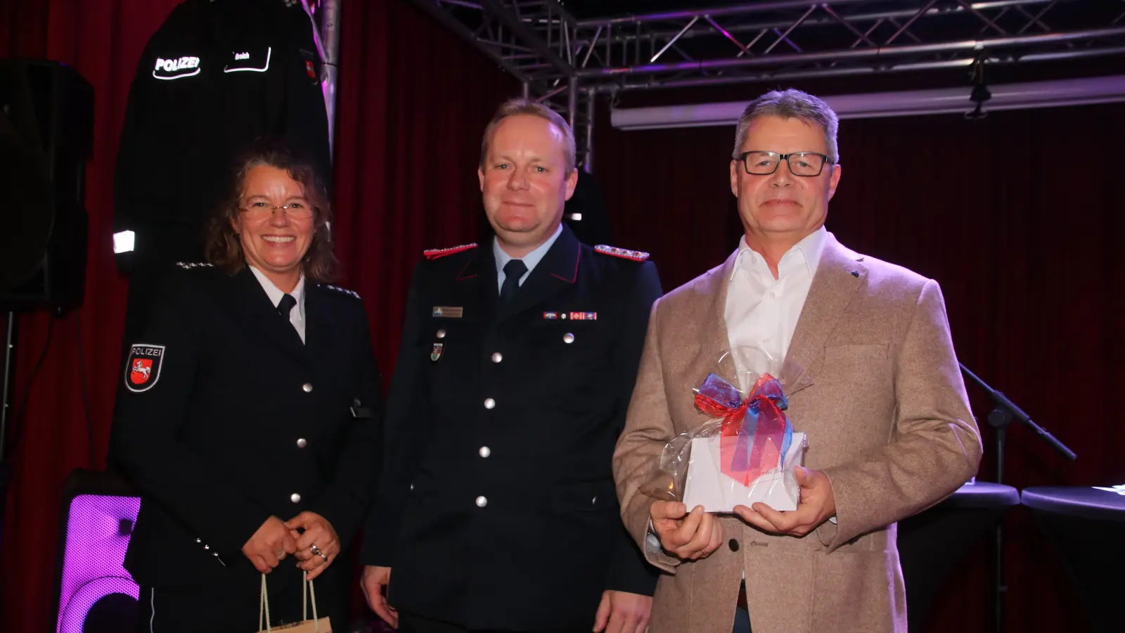 Auf der Bühne (v.li.): Britta Schwarz, Stadtbrandmeister Martin Ohlendorf und Thomas Broich. (Foto: gi)