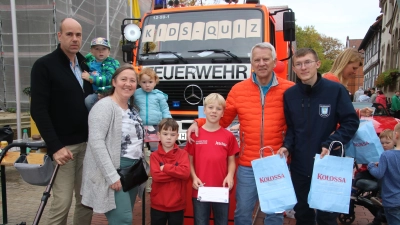 Übergabe: Bernd Heidorn (2.v.re.) und Mitglieder der Jugendfeuerwehr verteilen zwei Tüten an die Kinder der Familie Göhring aus Wunstorf.  (Foto: gi)