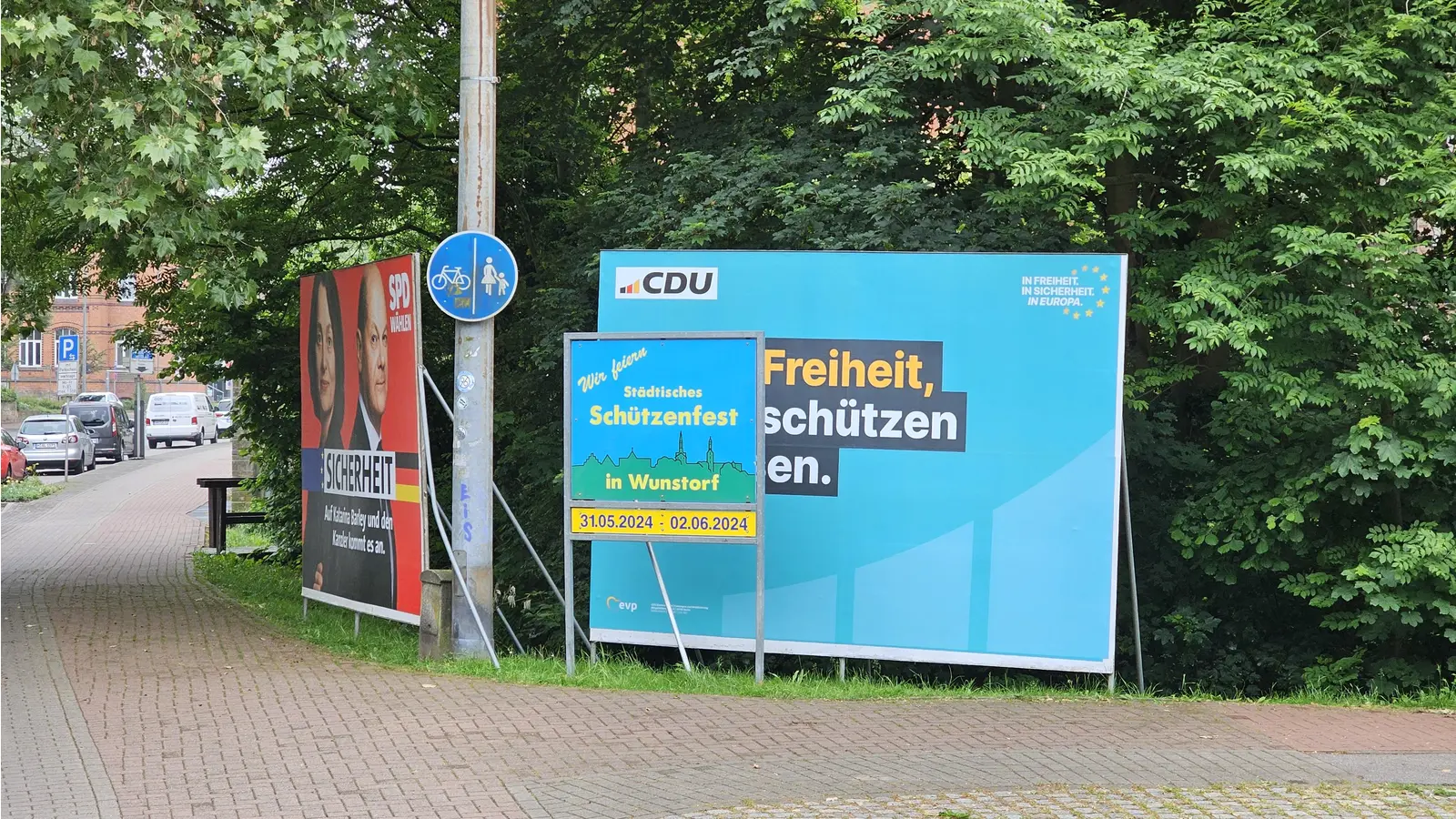 Unglücklich: Die Werbung fürs Schützenfest steht direkt vor einem Wahlplakat. (Foto: tau)