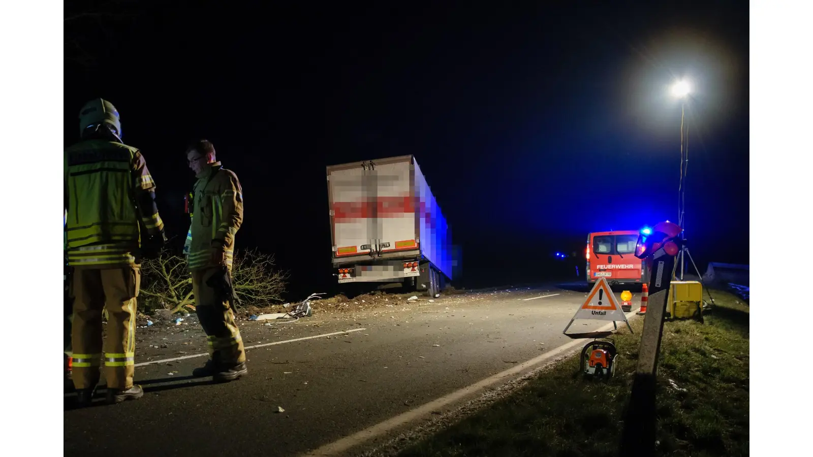 Feuerwehrleute besprechen das weitere Vorgehen, im Hintergrund Teile eines gefällten Baumes und der havarierte Sattelschlepper. <br><br> (Foto: bb)