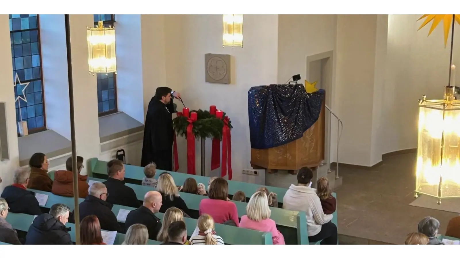 Pastor Dirk Bangert zündet die zweite Adventskerze an. (Foto: Koller)