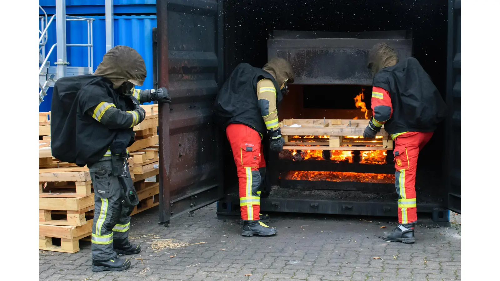 Teilnehmer werfen Brennholz nach, um Wärme und Brandrauch im Innern der Anlage zu erzeugen.  (Foto: Jedamzik)